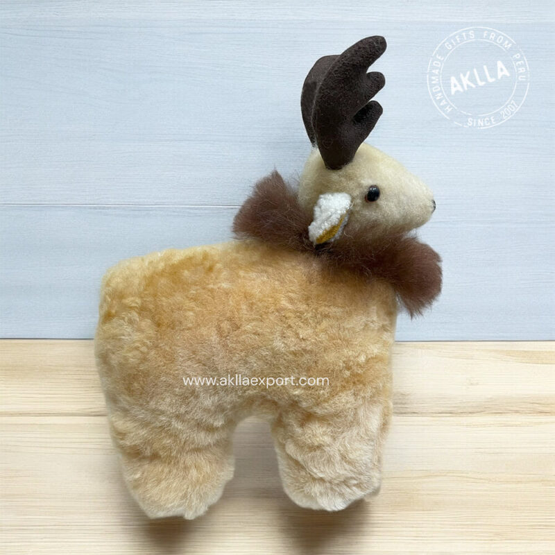 Reindeer plush toy made of soft alpaca fur, sitting on a wooden table with festive antlers and a red nose, creating a cozy winter display.