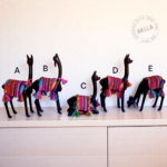 Handcrafted llama figurine and wooden vicuña carved from mohena wood with colorful Andean textile mantle