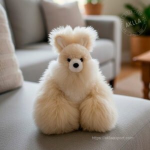 Handmade alpaca stuffed animal rabbit in creamy white fiber sitting on sofa showing full fluffy body and ears