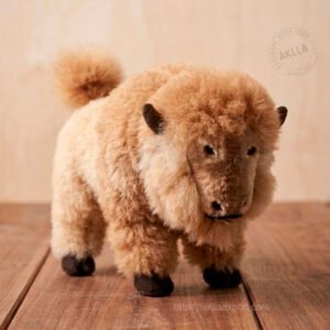 Handmade alpaca stuffed toy bison in 100% alpaca fiber standing on wooden surface showing full artisan detail