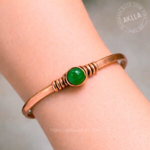 Handmade pure copper bracelet with green gemstone cabochon coiled setting worn on wrist