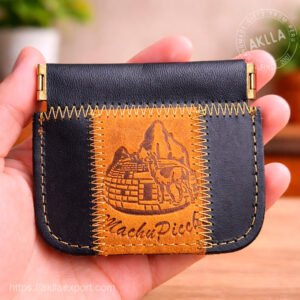 Handmade leather coin purse held in hand showing embossed Machu Picchu and llama design on tan leather panel