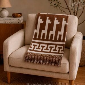 alpaca blanket in terracotta brown with llama pattern draped over armchair in cozy living room