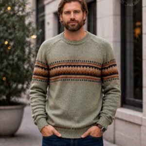 Man wearing men's alpaca sweater in army green with Fair Isle Andean pattern on chest outdoors